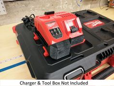 a red and black tool box on top of a workbench with the words charger & tool box not included