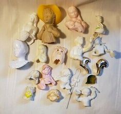 there are many small figurines on the table together, including one baby doll