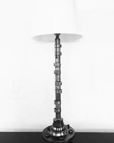 a lamp sitting on top of a black table next to a white wall and floor