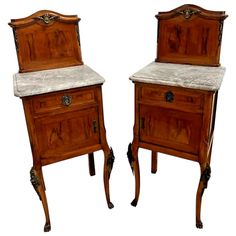 two wooden side tables with marble top and legs, one is turned down to look like the other