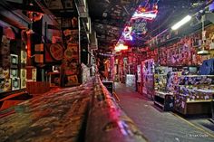 the inside of a store with many items on display and lights hanging from the ceiling