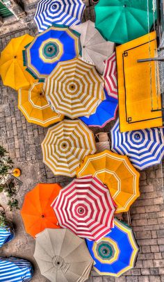 many colorful umbrellas are laying on the ground