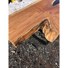 a piece of wood sitting on top of gravel next to a pile of dirt and rocks