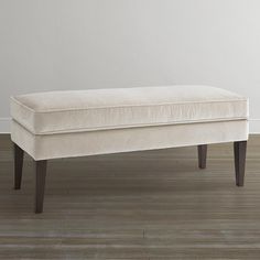 a white bench sitting on top of a hard wood floor