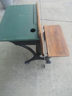 a green table with two pieces of wood sitting on it's legs next to a potted plant