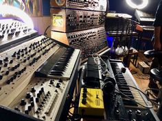 a man standing in front of an assortment of musical instruments and sound equipment on display