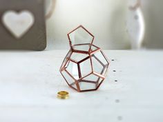 a ring that is sitting on a table next to a heart shaped object and some other items