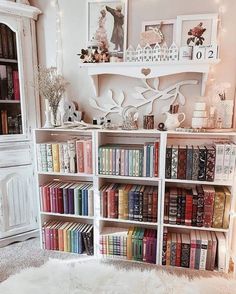 a book shelf filled with lots of books next to a white chair and wall mounted shelves