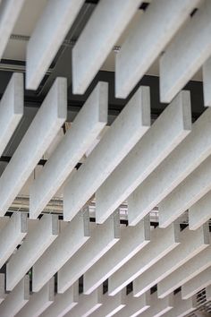 the ceiling is covered with white and black squares, which are suspended by metal bars