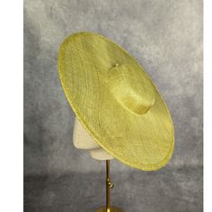 One cartwheel sinamay straw hat base in pear yellow / green that measures approximately 15" (38cm) in diameter. Crown is 1.5" (3.8cm) high. The edges of the brim are finished in wired sinamay. The multi-layer stiffened sinamay straw has a great sturdy weave and provides excellent support for your millinery creations. Sinamay is a natural material and you will see occasional beige / brown fibers / striations in the weave. This is not a defect, but is the result of how different natural fibers respond to dye and processing. This is NOT a ready to wear finished hat and will not stay on your head unless you add a head band or elastic to wear. Add embellishments of your choice.  A nice high quality base - I know you'll be pleased! The pear green base is in the first 3 photos. The green hat base Gold Wide Brim Mini Hat For Kentucky Derby, Gold Wide Brim Mini Hat For Spring, Gold Wide Brim Mini Hat, Gold Brimmed Mini Hats For Spring, Gold Mini Hats With Curved Brim For Spring, Gold Top Hat For Kentucky Derby, Gold Top Hat For Kentucky Derby And Church, Gold Wide Brim Fascinator For Summer, Gold Top Hat For Kentucky Derby Church Event