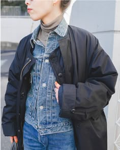 a woman wearing an oversize denim jacket and jeans