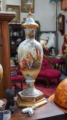 an ornate vase sitting on top of a wooden table next to other antique items in a room