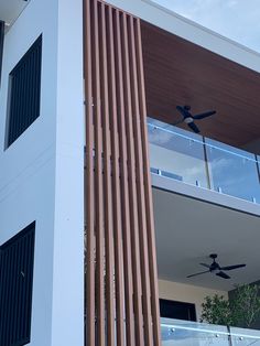 the ceiling fan is mounted to the side of this modern home's balcony area