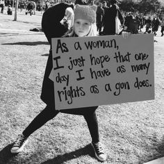 a woman holding a sign that says as a woman, i just hope that one day i have, as many rights as a gon does