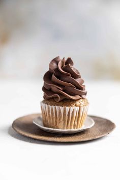 a cupcake with chocolate frosting on a plate