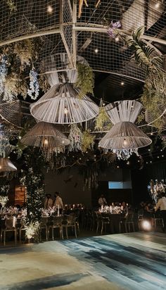 an indoor dining area with umbrellas hanging from the ceiling and tables set for dinner