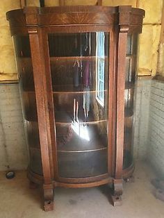 an old wooden china cabinet with glass doors