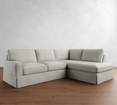 a white couch sitting on top of a hard wood floor next to a wooden floor