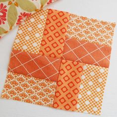 an orange and white patchwork quilt on a table