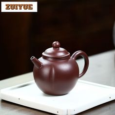 a brown teapot sitting on top of a white tray