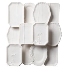 white ceramic plates with monogrammed designs on the sides and one in the middle