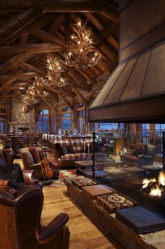 a living room filled with lots of furniture and a fire place in the middle of it