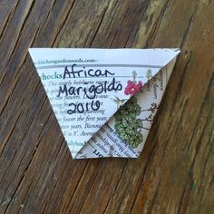 an origami paper flower on top of a wooden table with the words rocks africa written in it