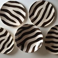 four zebra print plates sitting on top of a table