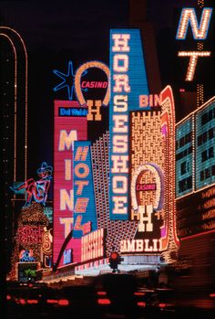 neon signs are lit up on the side of buildings in las vegas, nv