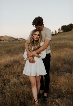 a man and woman hugging in a field