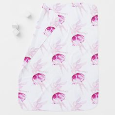 a pink and white towel with an image of a bird on it next to cubes