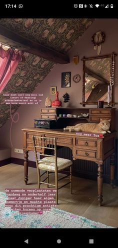 a desk with a chair and mirror in front of an attic bedroom wall hangings