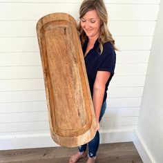 a woman holding a large wooden object in her hands