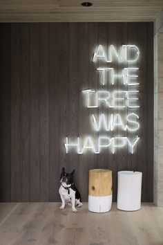 a black and white dog sitting in front of a sign that says and the tree was happy