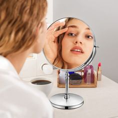 a woman looking at her face in the mirror