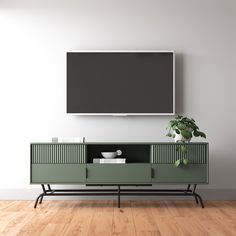 an entertainment center with a television mounted on the wall and a potted plant in front of it