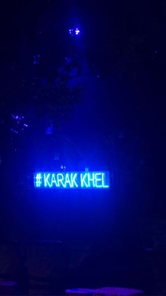 a neon sign that reads karak khel on it in front of a dark background