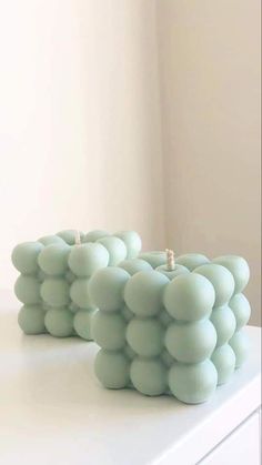 two candles sitting on top of a white table