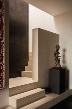 a sculpture sitting on top of a set of steps next to a painting and stairs