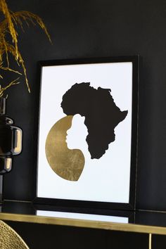 a framed black and gold silhouette of a woman's head