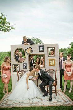 a bride and groom kissing in front of a photo booth with their wedding party photos