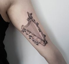 a black and white photo of a woman's arm with a tattoo on it