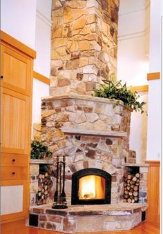 a fire place in the middle of a room with wood and stone on it's sides