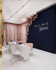 the interior of a restaurant with white chairs and pink flowers on the wall behind it