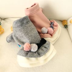 two pairs of baby shoes with pom - poms on the soles and one pair of slippers