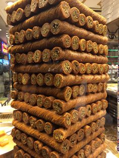 a large stack of logs sitting on top of a counter in a store filled with pastries