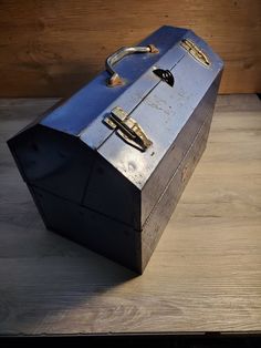 an old metal box sitting on top of a wooden table