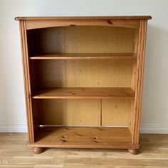 a wooden bookcase with three shelves on one side