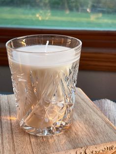 a glass candle sitting on top of a wooden table