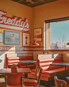 the interior of a restaurant with red booths and tables in front of a window that reads, friday's